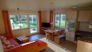 Een knus woongedeelte met een bank, eettafel en kitchenette.