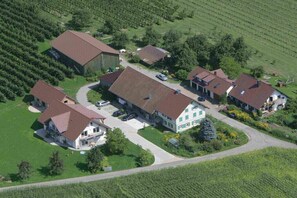 A residential area with multiple houses, a barn, and a driveway. - Bioland farm Teufelsberg (Horgenzell)