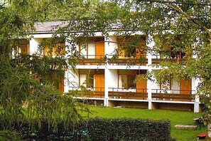 A multi-story building with balconies, surrounded by greenery. - Holiday apartment with 2 bedrooms (Steindorf)
