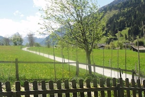 A rural landscape with a fenced field, a clear path, and a mountain backdrop. - Holiday apartment with 1 bedroom (Rauris)