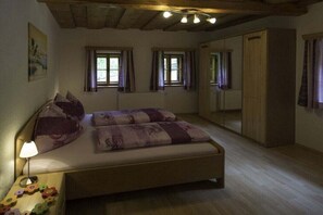 Un dormitori amb un llit, una vetust i un armari.