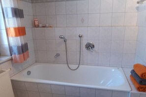 Un baño con bañera, ducha e inodoro.