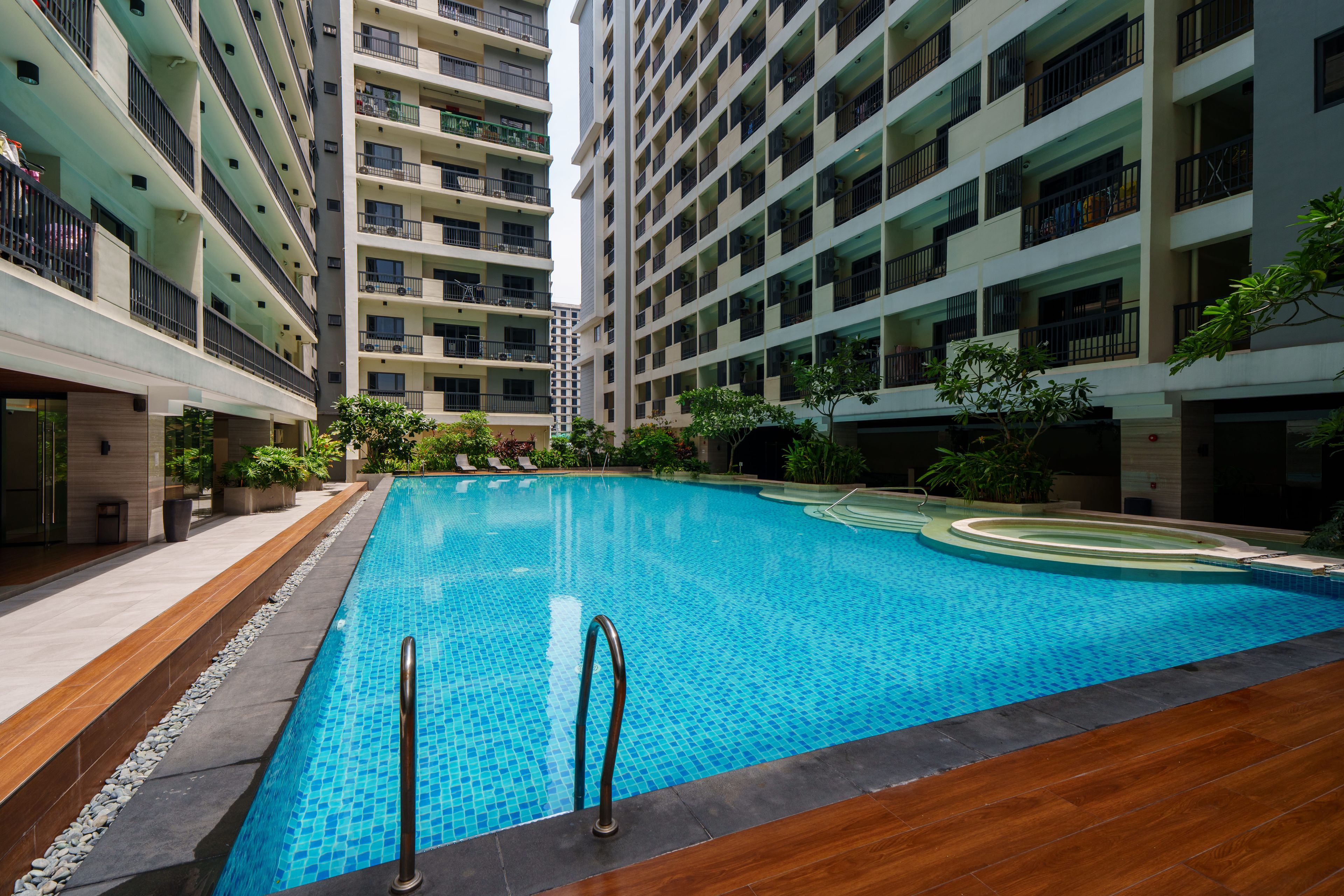 Una piscina rodeada de edificios residenciales de varios pisos con balcones.
