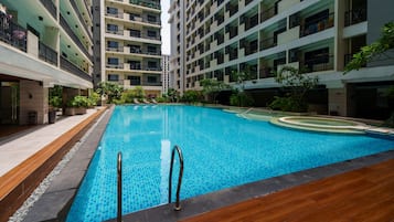 Una piscina rodeada de edificios residenciales de varios pisos con balcones.