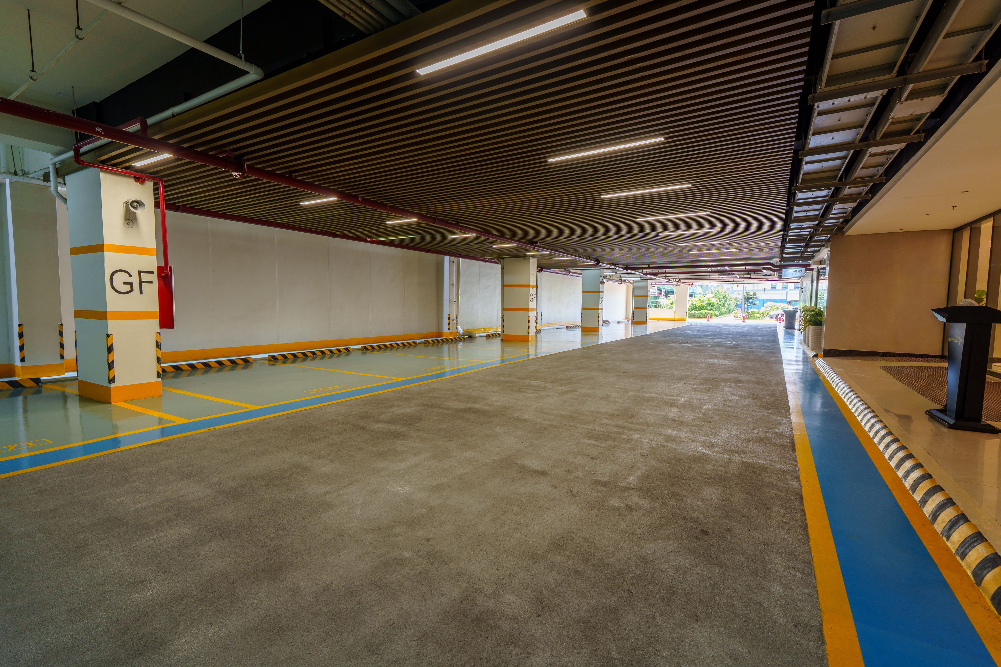 A spacious parking garage with clear lane markings and directional signs.