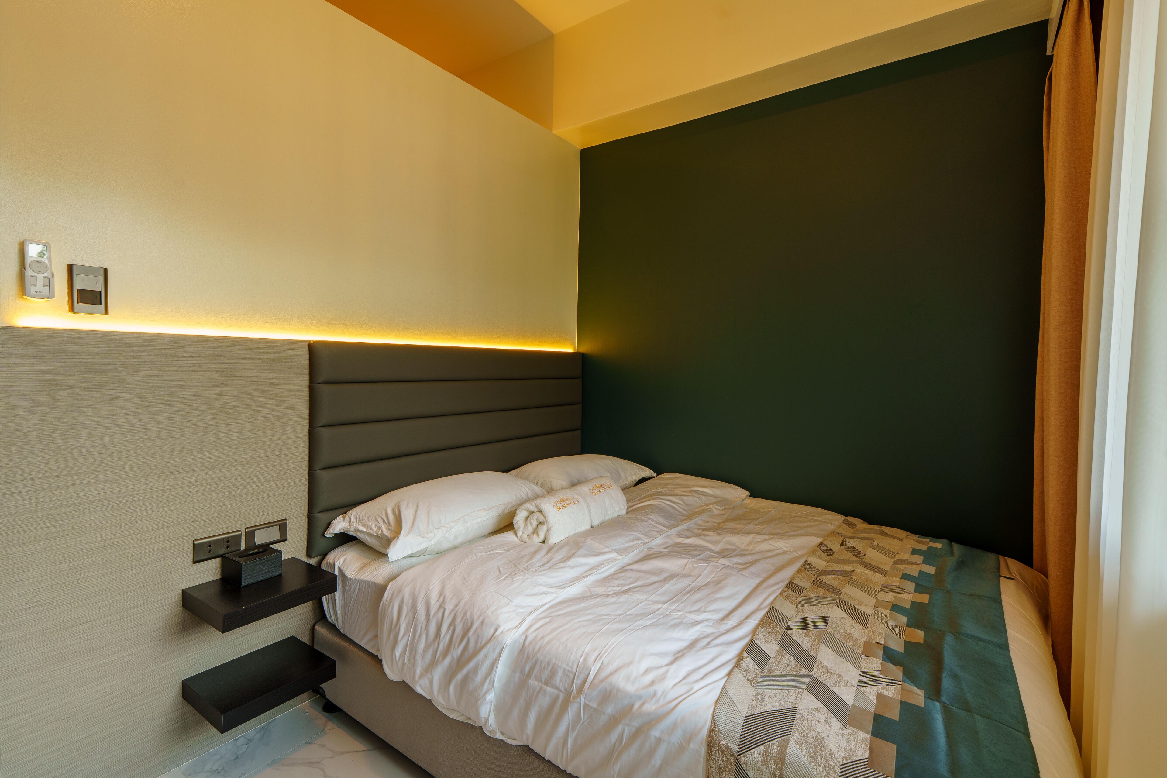 A modern bedroom with a bed, bedside tables, and a nightstand.