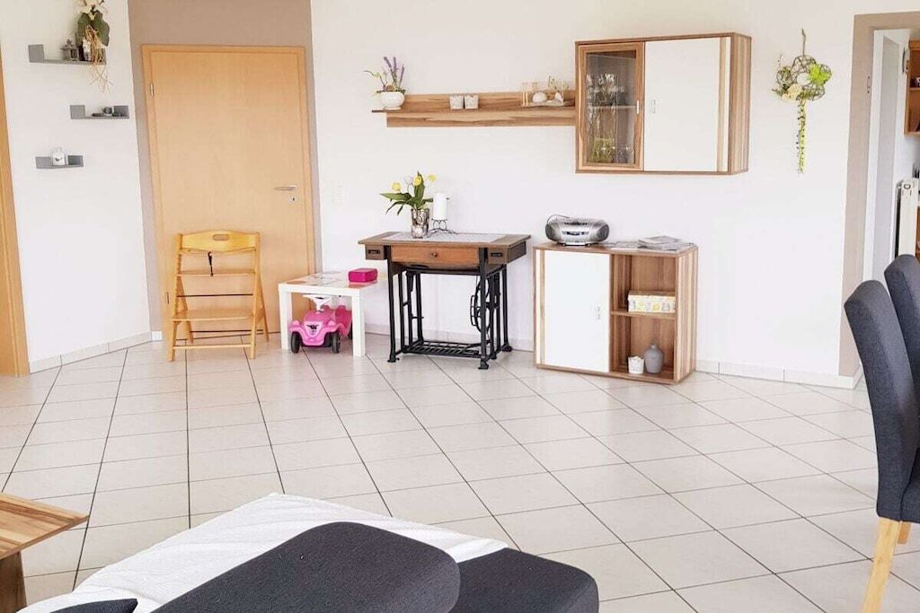 Habitació amb un llit, escriptori, cadira, prestatge amb plantes i un armari.