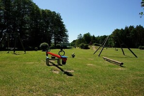 Ein Park mit einer Schaukel, einer Wippe und einer Bank.