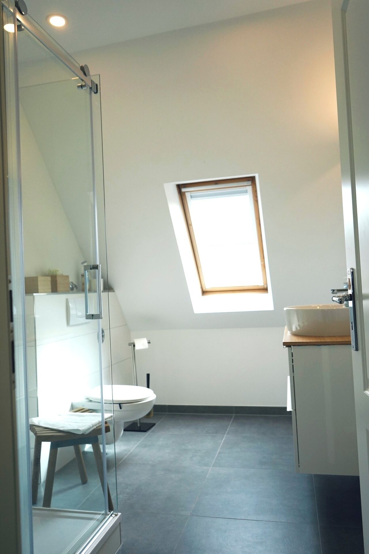 Ein modernes Badezimmer mit Oberlicht, Toilette und Waschbecken.