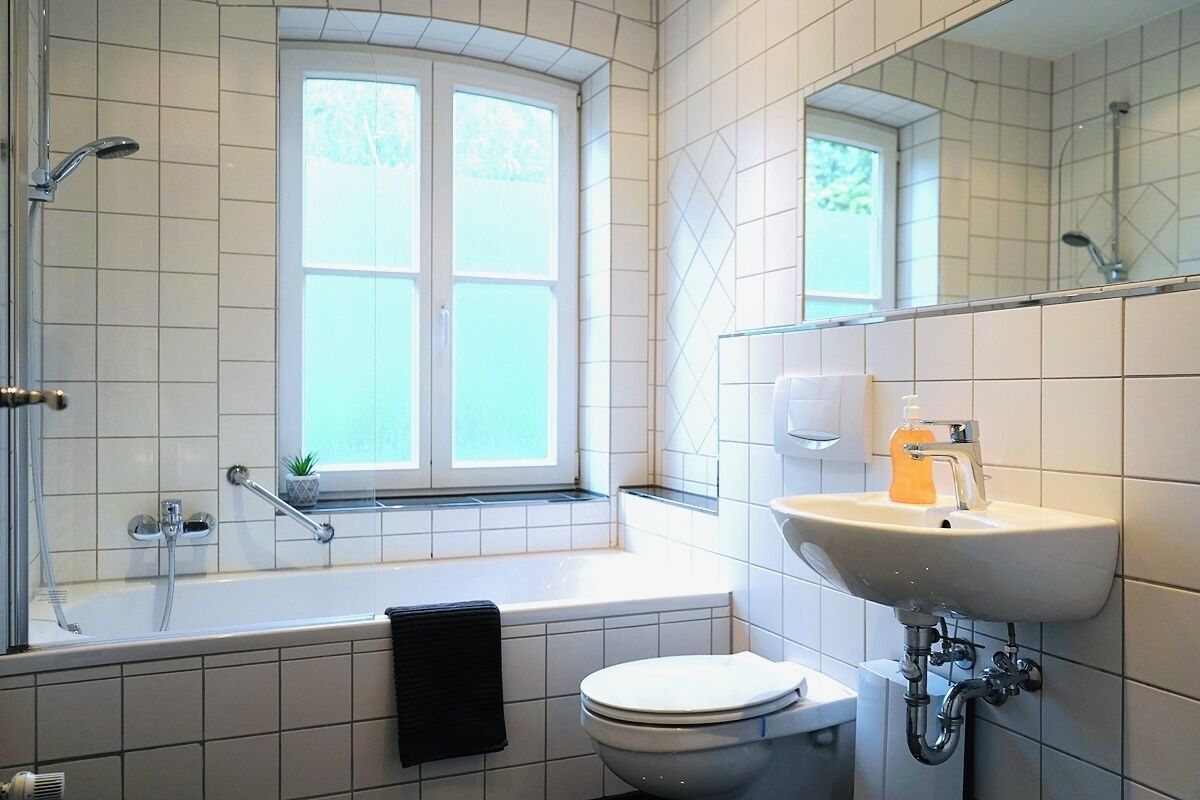 A bathroom with a bathtub, toilet, and sink.