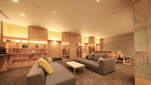 A modern living room with built-in shelving, a sofa, and a coffee table. - Richmond Hotel Tenjin Nishi-dori (Fukuoka)