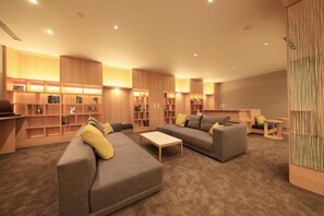 Uma sala de estar moderna com estantes embutidas, um sofá e uma mesa de centro.
