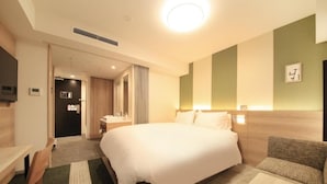 A hotel room with a large bed, a desk, a chair, a sofa, and a television. - Richmond Hotel Tenjin Nishi-dori (Fukuoka)