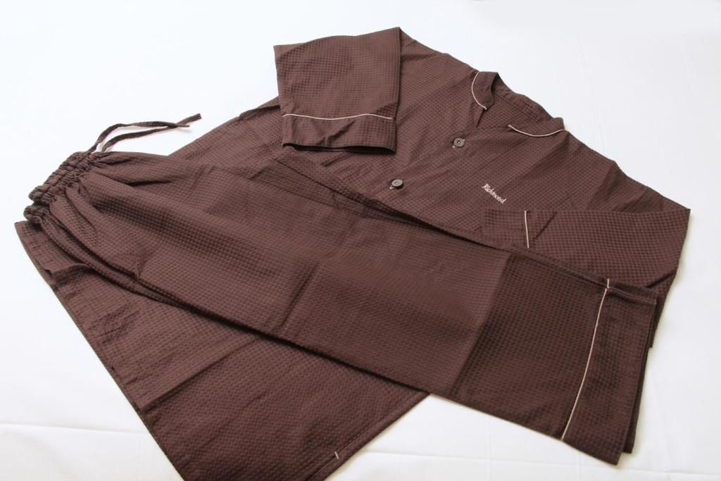 Uma peça de roupa marrom com gola e botões, estendida.