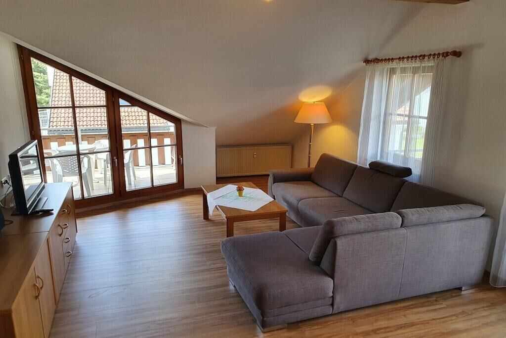 A living room with a sofa, a coffee table, and a TV on a wooden cabinet.