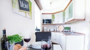 A small kitchenette with white cabinets, a microwave, and a coffee maker. - Ordinger Dün Holiday Apartment 6 (St. Peter-Ording)