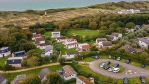 Un quartier résidentiel situé sur la côte, avec des maisons, un parking et une vue sur la mer.