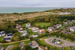 Een kustwoonwijk met huizen, een parkeerplaats en uitzicht op zee.