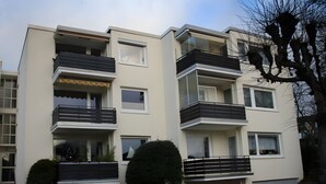 Un edificio residencial de varios pisos con balcones, ventanas y fachada plana.