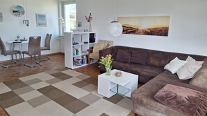 Una sala de estar moderna con un sofá marrón, una mesa de centro blanca y una alfombra a cuadros.