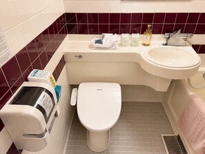 A bathroom with a toilet, sink, and a hand dryer. - WASHUKAN HOTEL  (Gyoda)