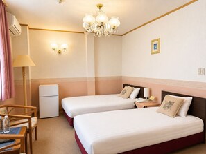 A hotel room with two beds, a desk, a chair, a lamp, a refrigerator, and a chandelier. - WASHUKAN HOTEL  (Gyoda)