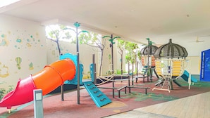 A children's play area with a red slide, climbing structures, and a jungle-themed wall. - Cozy Suites at Saville Cheras by HCK (Cheras)
