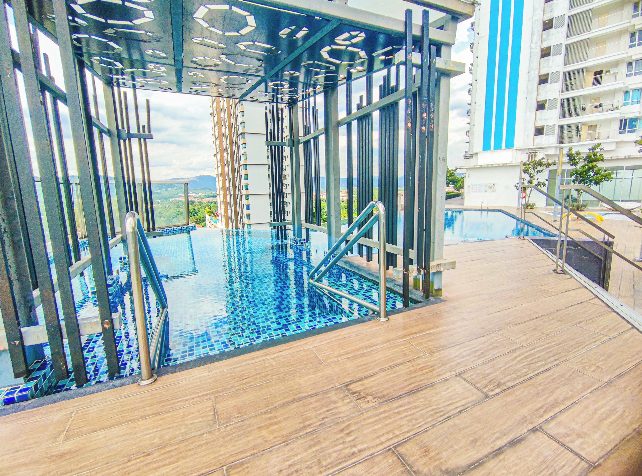 An indoor infinity pool with a view of a cityscape, surrounded by a modern architectural structure.