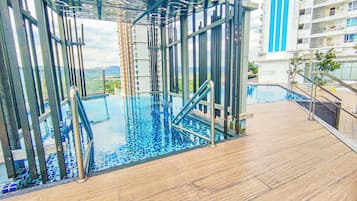 An indoor infinity pool with a view of a cityscape, surrounded by a modern architectural structure.