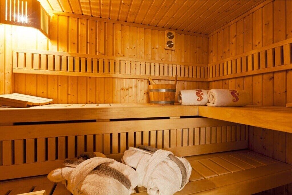 A sauna room with wooden walls and benches.