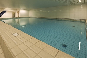 An indoor swimming pool with tiled walls and a tiled floor. - Holiday apartment in Norderney with sauna (Norderney)