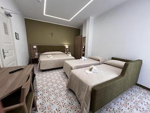 A hotel room with two single beds, a wooden desk, and a small table.