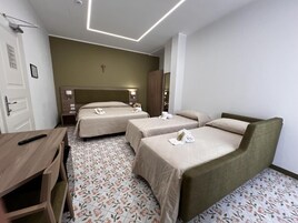Una habitación de hotel con dos camas individuales, un escritorio de madera y una mesita.