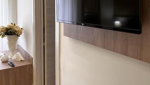 A flat-screen TV mounted on a wall with a wooden panel design.