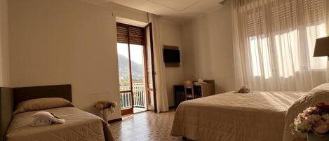 Une chambre d’hôtel avec deux lits, une télévision et un balcon.