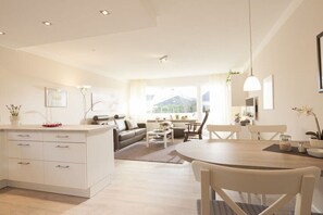 A modern living space with a kitchen, dining area, and seating area. - Holiday apartment in Norderney with Wi-Fi (Norderney)