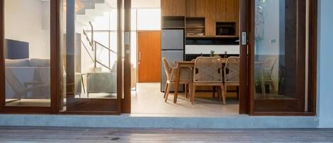 Un interior moderno con comedor, cocina y piscina.
