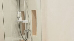 A bathroom with a glass-enclosed shower, a white toilet, and a wooden vanity. - PT Residence Chonburi (Mueang Chon Buri)