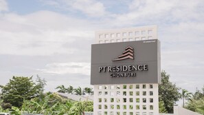 PT Residence Chonburi -hotellin kyltti, jossa on moderni muotoilu ja logo.
