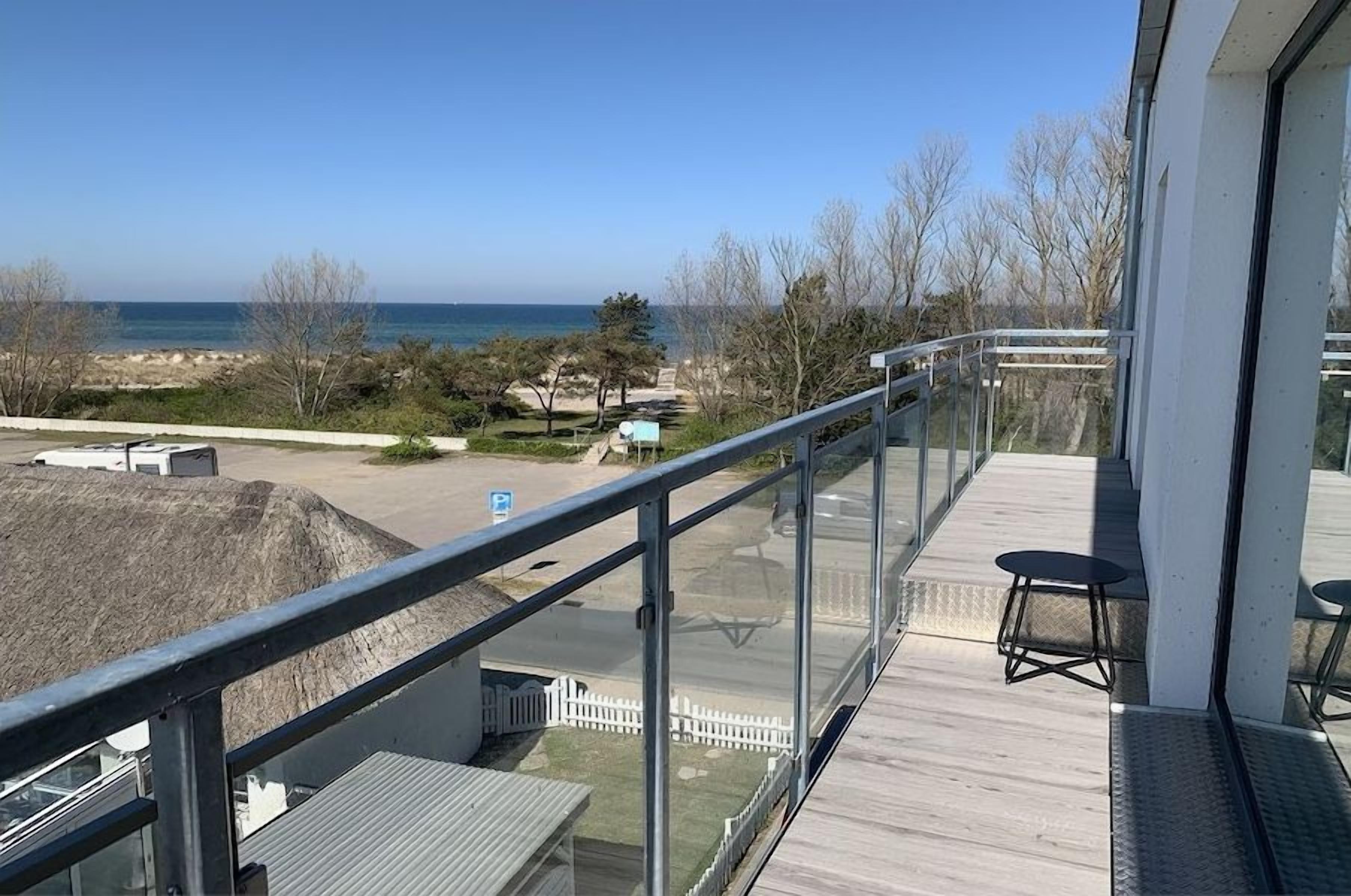 Un balcon avec vue sur la plage et l’océan.