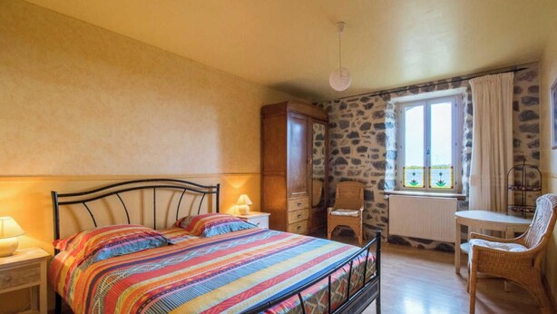 Un dormitorio con cama, escritorio, silla y armario.
