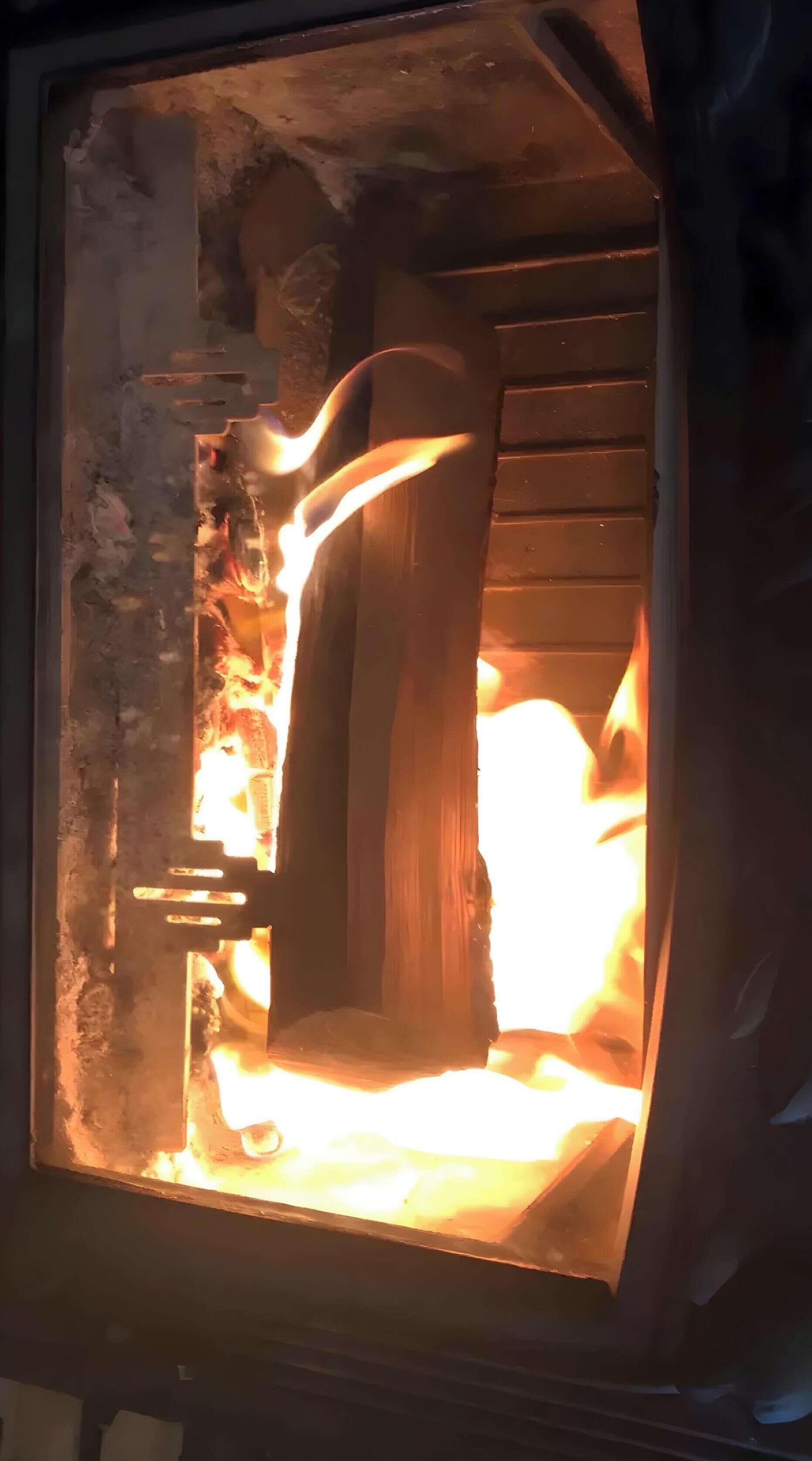 A fireplace with a log burning inside.