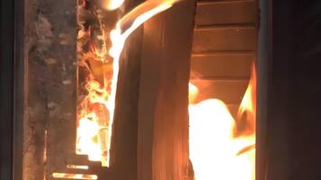 A fireplace with a log burning inside.