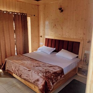 Une pièce en bois avec un lit, des rideaux et une tête de lit en bois.