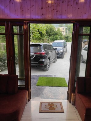 Una habitación con vistas a coches aparcados a través de puertas de cristal.