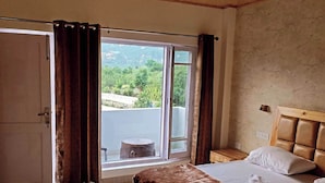 A bedroom with a bed, a window with curtains, a view of greenery outside, and a wooden ceiling. - The Veteran House (Haripur)
