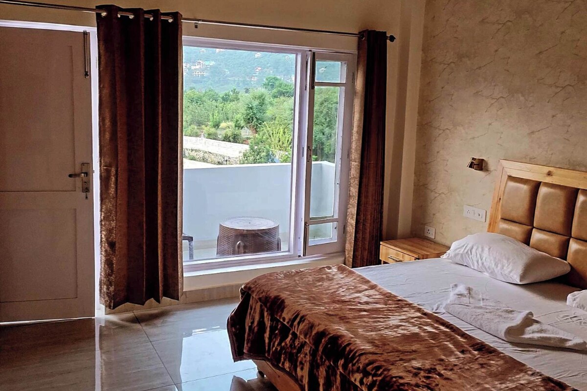 Quarto com cama, janela com cortinas e vista para o verde lá fora, além de teto de madeira.
