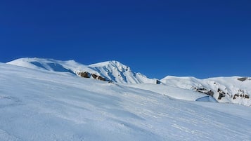 A snow-covered mountain landscape with clear blue skies.