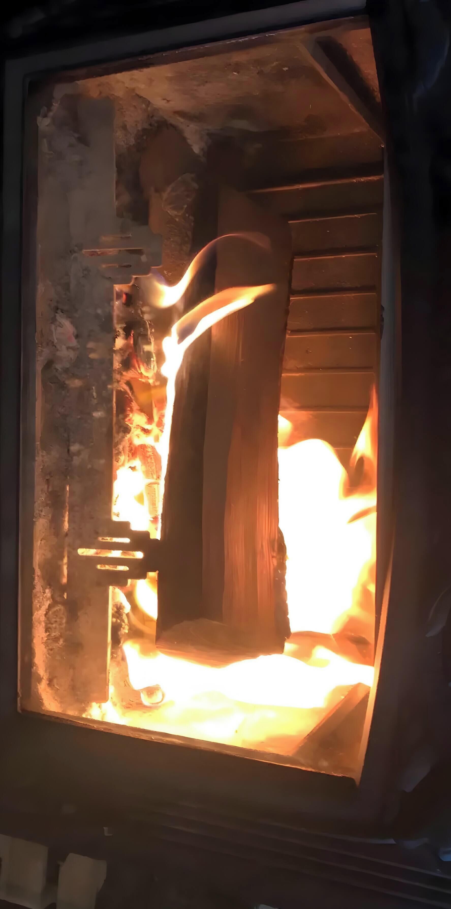 Un camino con un ceppo di legno che arde all'interno.