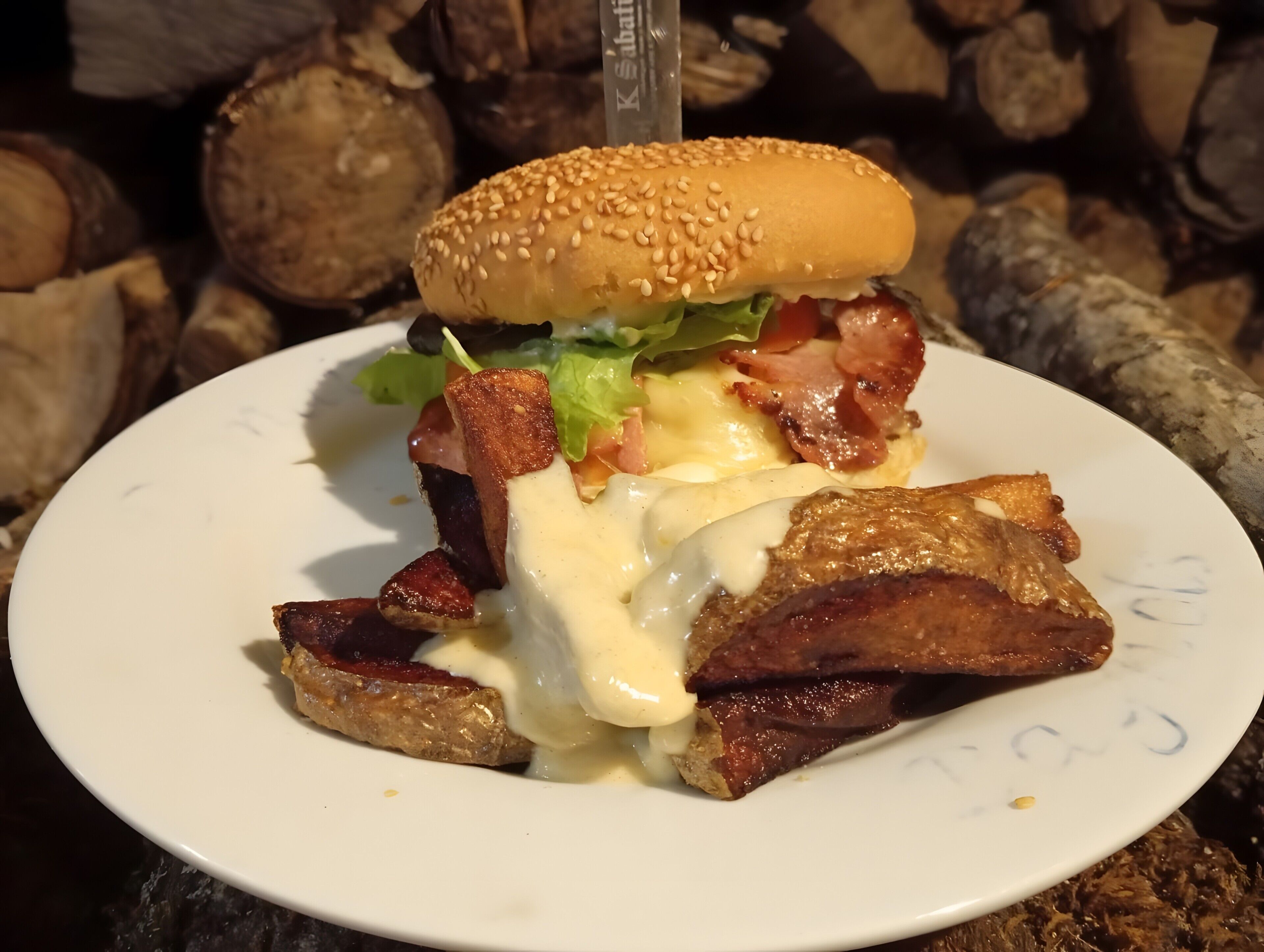 Un plato con una hamburguesa, tocino y papas fritas.